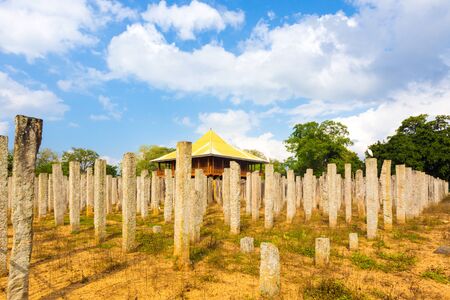Corner view of original stone pillars that remain at the ruins of the Brazen Palace or Lovamahapaya on a cloudy blue sky day in ancient Anuradhapura capitol in Sri Lankaのeditorial素材