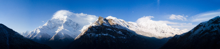 Panoramic view of beautiful blue sky behind Himalayan Annapurna mountain range and snow capped peaks on a cold spring morning seen from Ghyaru, Nepalの写真素材