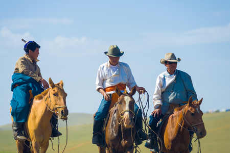 Ulaanbaatar, Mongolia - June 12, 2007: Three Mongolian cowboys on horseback approach riding horses in traditional clothes and cowboy hatsのeditorial素材