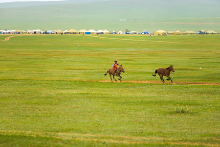 Ulaanbaatar, Mongolia - June 12, 2007: Young boy on horseback leading the pack at the horse racing competition event of the Naadam Festivalのeditorial素材
