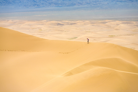Khongor Els, Mongolia - July 20, 2007: A person providing comparative scale to the  height of the massive Khongor Els sand dunes at the Gobi Desertのeditorial素材