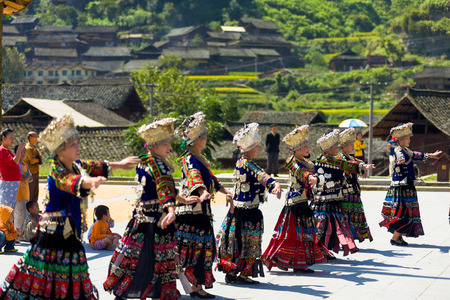 Xijiang, China - September 15, 2007: Miao women dancing in full traditional festival regalia and colorful costume with silver horn headdress in Xijiang ethnic minority Miao village, Guizhou, Chinaのeditorial素材