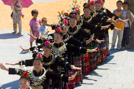 Xijiang, China - September 15, 2007: Line of Miao women dance wearing full traditional festival regalia and colorful costume at Xijiang ethnic minority Miao village, Guizhou, Chinaのeditorial素材