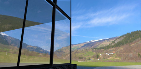 The stunning mountain scenery is reflected on the glass facade of a modern, newly built home. 3d...