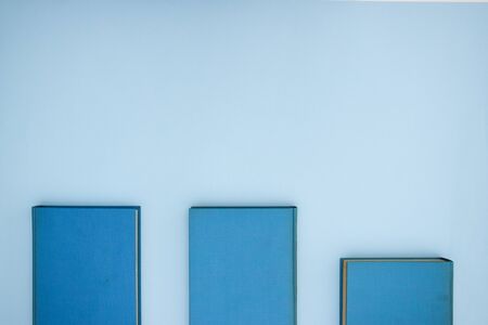 Three blue books on the blue background