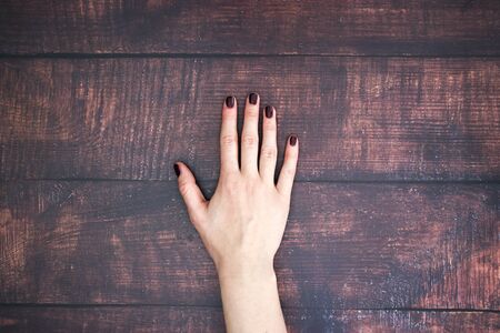 Woman's hand on the wooden backgroundの写真素材