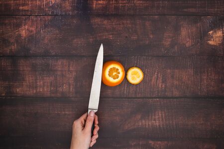 Knife cut orange on the wooden tableの写真素材