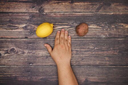 Man's hand and fresh fruits around on the wooden tableの写真素材