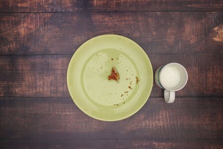 Jam on the bread and cup of milk on the table for breakfastの写真素材