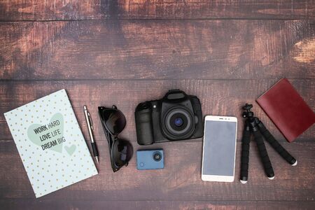 Travel kit and cameras on wooden background