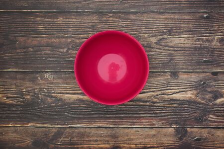 Empty red dish on wooden table