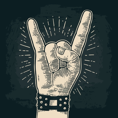 Rock and Roll sign. Hand with metal spiked bracelet giving the devil horns gesture. Vector monochrome vintage engraved illustration. Isolated on dark background. For festival posterのイラスト素材
