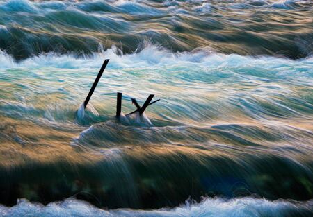Water flowing over the weirs picks up speed as it flows of debris left over from recent flooding on...