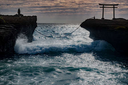 The torii gate that sits atop this huge rock is a part of the Ikonabi Hime Shrine, whose founding dates back to over 2,400 years. The shimenawa rope âwedsâ the two rocks together and sets the boundary for the sacred space which extends from the two rocks to the shrine located inland.の写真素材