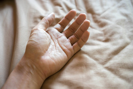 Close-up of hand on the bedの写真素材