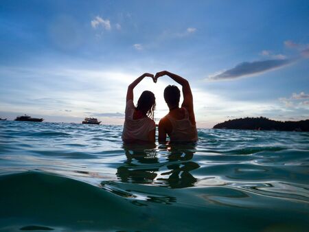 Couple make sign love on seaの写真素材