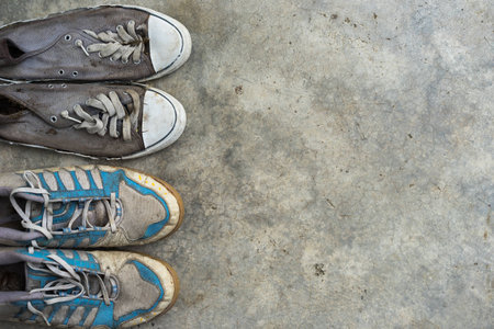 Top view Shot of some dirty sneakers for copy space on Cement textured backgroundの写真素材