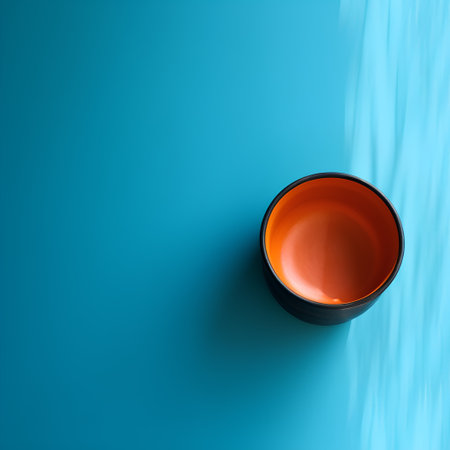Orange glass on blue background. 3d render illustration with copy spaceの素材