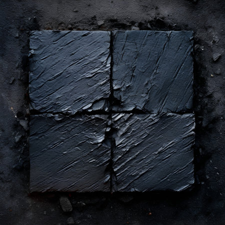 Piece of black slate on a black background. Top view.の素材