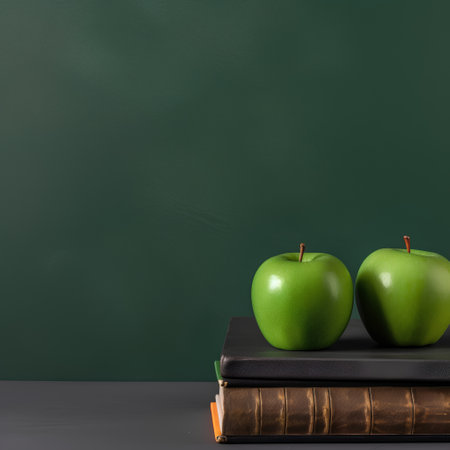 Green apples and books on blackboard background. Back to school conceptの素材