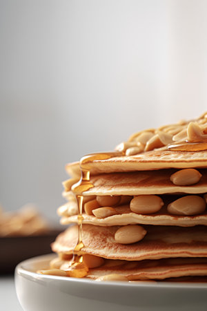 Pancakes with honey and nuts on a light background. Selective focus.の素材