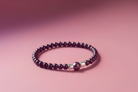 Bracelet made of natural stone beads on a pink background.の素材