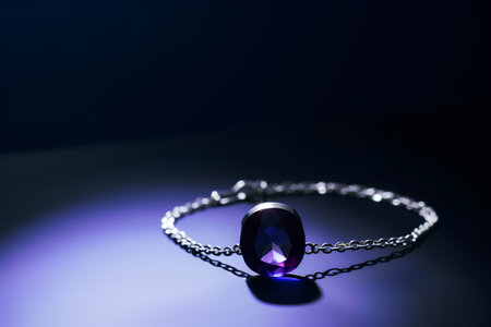 Necklace with blue sapphire on a dark background.の素材