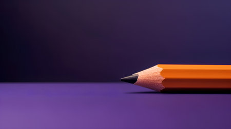 Orange pencil on a purple background. Back to school. Copy space.の素材