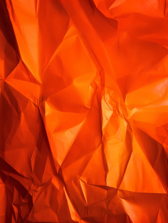 Orange creased crumpled paper background grunge texture backdrop.の素材