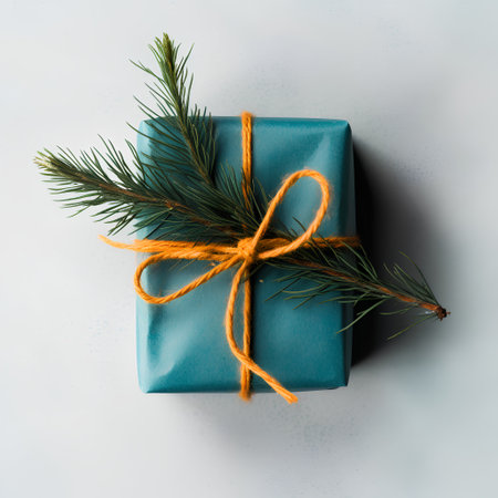 Christmas or New Year composition with blue gift box and fir tree branch on white background. Flat lay, top viewの素材
