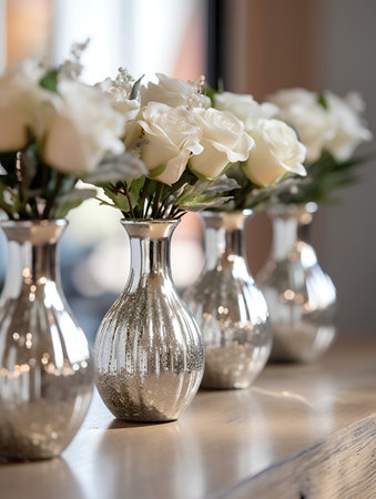 Beautiful white roses in vases on the table in the roomの素材