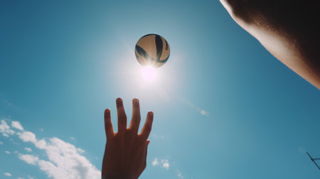 Rugby ball in the hand of a man on a background of blue skyの素材