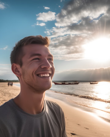 Portrait of a smiling young man on the beach at sunset in summerの素材