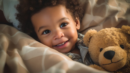 Cute african american little girl lying in bed with teddy bearの素材