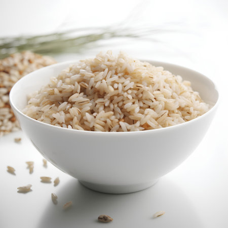 Brown rice in white bowl on white background, close-up.の素材