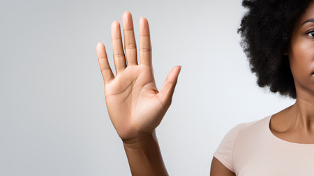 Young african american woman showing stop gesture, isolated on grey backgroundの素材