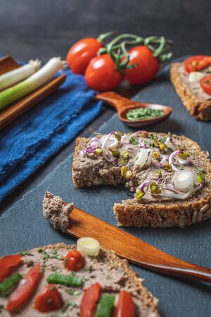 Homemade Rustic Pate on Bitten Slice of Bread with Fresh Vegetablesの写真素材