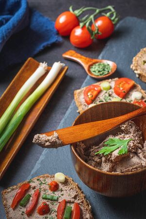 Homemade Rustic Pate on Bitten Slice of Bread with Fresh Vegetablesの写真素材