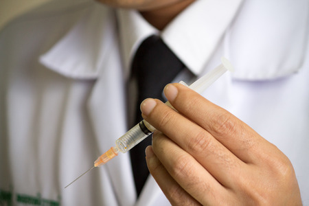 Doctor holding medical injection syringeの写真素材