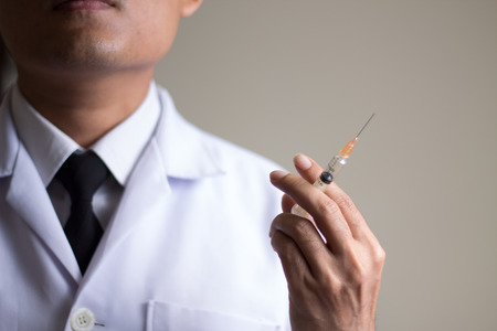 Doctor holding medical injection syringeの写真素材