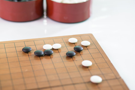 Game's white and black stone on cross board.の写真素材
