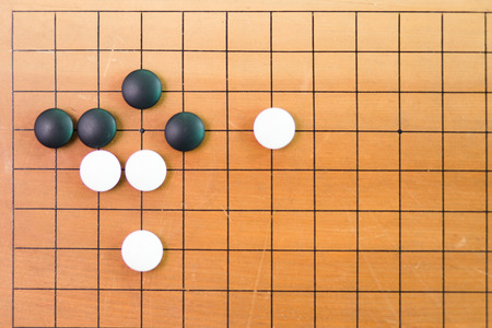 Game's white and black stone on cross board.の写真素材