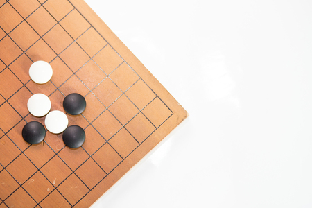 Game's white and black stone on cross board.の写真素材