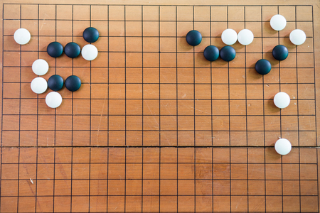 Game's white and black stone on cross board.の写真素材