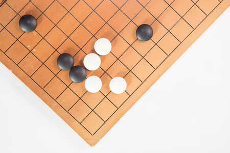 Game's white and black stone on cross board.の写真素材