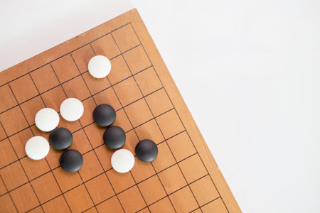 Game's white and black stone on cross board.の写真素材