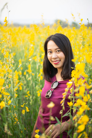 Young woman in a field of yellow flowersの写真素材