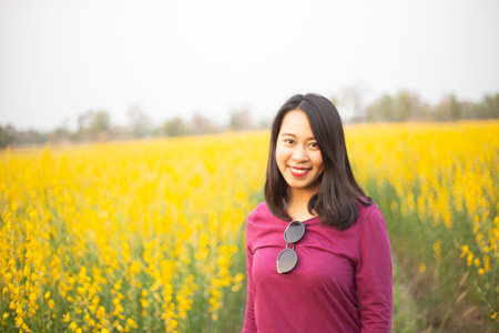 Young woman in a field of yellow flowersの写真素材