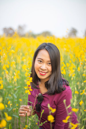 Young woman in a field of yellow flowersの写真素材