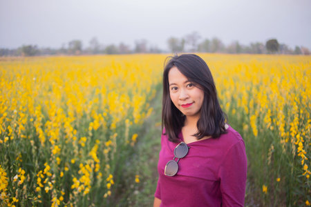 Young woman in a field of yellow flowersの写真素材